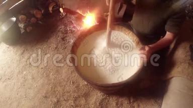 在木桶和篝火中搅动发酵的羊奶<strong>木器</strong>