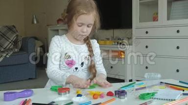 一个小女孩玩橡皮泥，滚球，桌面上有图形和彩色铅笔，发展