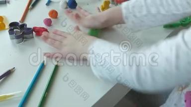 一个小女孩玩<strong>橡皮泥</strong>，滚球，桌面上有图形和彩色铅笔，发展