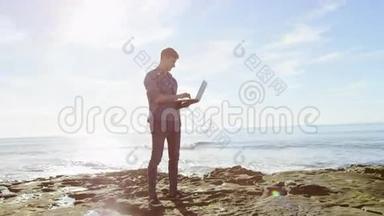 沙滩上有笔记本电脑的年轻人