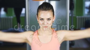 女子在健身房里用举重的<strong>蝶形</strong>机进行健身训练