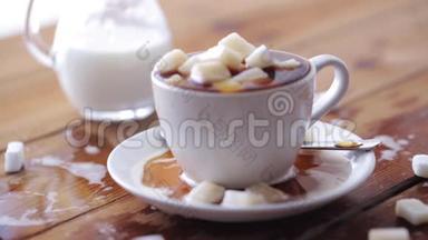 木桌上放满糖块的咖啡杯