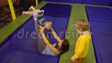 母亲和她的儿子在健身公园跳<strong>蹦床</strong>，在室内做<strong>运动</strong>