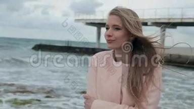 穿着粉色外套在海边的快乐女孩