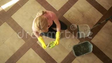 女人打<strong>扫地</strong>板。 戴手套的女孩打扫厨房
