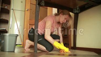女人打<strong>扫地</strong>板。 戴手套的女孩打扫厨房