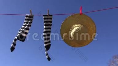 女式袜子和夏季草帽在蓝天上迎风洗衣服