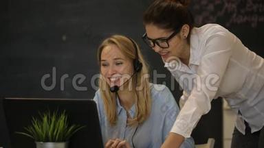 两个年轻的女商人在电脑上工作，并在电脑上抽烟