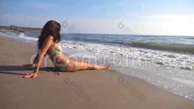 穿比基尼的年轻女孩躺在<strong>海边</strong>和日光浴。 无法辨认的女人在夏天在<strong>海边</strong>放松