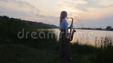 黎明时分，一位年轻女子在河岸附近的萨克斯管上演奏，一位穿着一件长带着风的美丽女孩的剪影