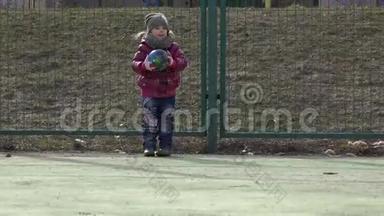 女孩踢足球。 带球的婴儿在运动场上。 4k超高清