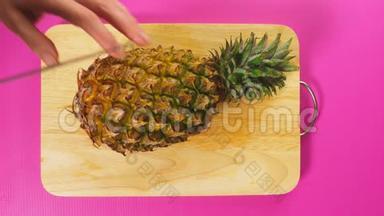 俯视图，女手用刀<strong>切水果</strong>在木板上，菠萝.. 天然健康食品<strong>的</strong>概念..