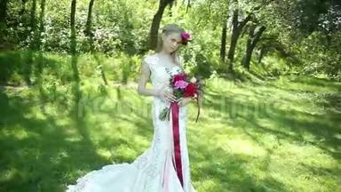 带火车的婚纱。 美丽的婚礼花束在年轻新娘手中。 婚礼。 公园里的年轻女子