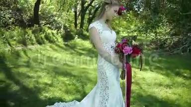带火车的婚纱。 美丽的婚礼花束在年轻新娘手中。 婚礼。 公园里的年轻女子