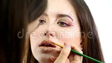 化妆师把纸屑放在嘴唇上。 嘴唇上的纸屑，美丽的妆容和明亮的嘴唇颜色