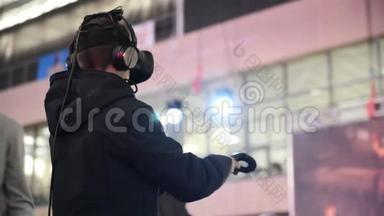 这家伙在VR耳机虚拟现实中玩游戏在一个会议活动。