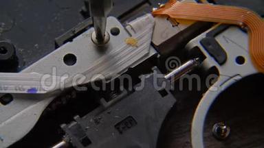 松开螺丝。 一只手拿着螺丝刀正在安装或修理电脑部件。