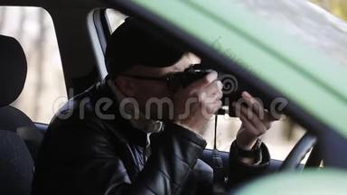 私家侦探坐在车里用数码相机拍照