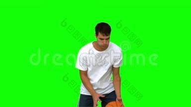 一个英俊的男人在绿色的屏幕上<strong>接球</strong>和投掷<strong>篮球</strong>
