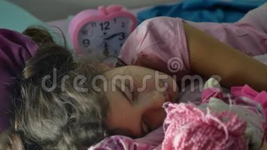 可爱的小女孩晚上睡在沙发床上，拥抱她的室内娃娃。 女孩深肤色的少年可爱的睡着了