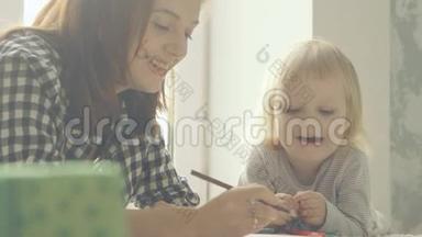 妈妈和小女儿用<strong>铅笔</strong>在相册里<strong>画画</strong>
