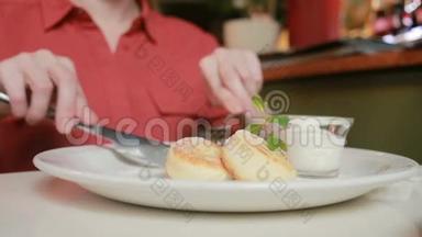 那个在咖啡馆里吃奶酪煎饼的女孩用酸奶油叉和刀。