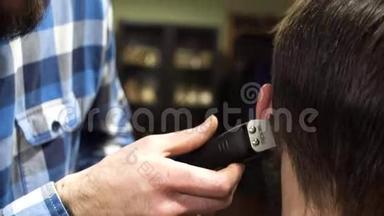 一个留胡子的理发师用梳子和修剪器仔细地给他的客户理发的肖像。 4K