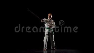 剑道战士在白色和服上练习<strong>武术</strong>，与竹子在黑色<strong>背景</strong>上。