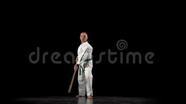 剑道战士在白色和服上练习<strong>武术</strong>，与竹子在黑色<strong>背景</strong>上。