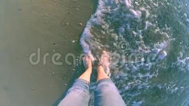 女孩站在海边，海浪拍打着她的脚