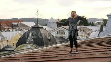 女人一边听着耳机里的音乐，一边在屋顶上跳舞，一边感到快乐。