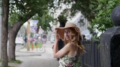 戴着帽子的漂亮年轻女人带着冰淇淋在城市里走来走去