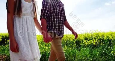 浪漫的情侣在野外散步时牵手