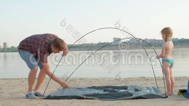 一个成熟的人在海边的户外度假时收集帐篷