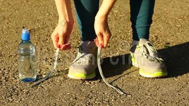 女孩停止跑步，把鞋带系在<strong>跑鞋</strong>上。 健身女孩在户外训练。 高清120f