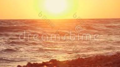 日落时海边的巨浪。 橙色太阳背景下美丽的慢动作视频