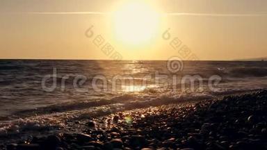 日落时海边的巨浪。 橙色太阳背景下美丽的慢动作视频