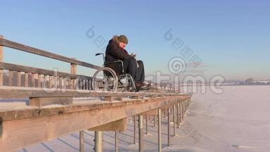 冬天在湖边坐轮椅的残疾人