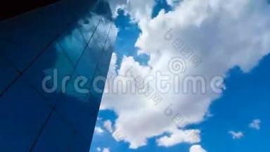 仰望一座玻璃覆盖的摩天大楼，映着蓝天和白云