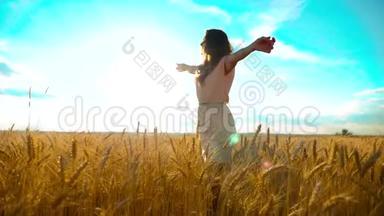 美女户外欣赏大自然麦田慢动作视频.. 美丽的女孩穿着白色的裙子奔跑着大自然的自由