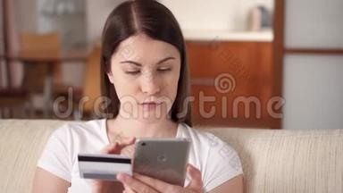 年轻女子坐在客厅沙发上，用智能<strong>手机刷</strong>卡上网
