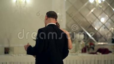 一对年轻漂亮的已婚夫妇在餐馆恋爱的第一支婚礼舞。