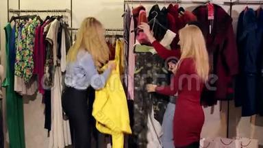 三个美丽的年轻女人在一家<strong>服装店购物</strong>的肖像。