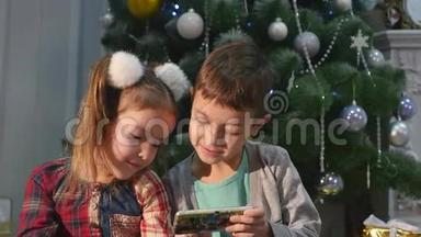 儿童在圣诞树附近<strong>玩手机</strong>、儿童和智能<strong>手机</strong>