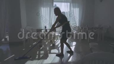 女人做清洁。 女孩打扫地板拖把。 清洁