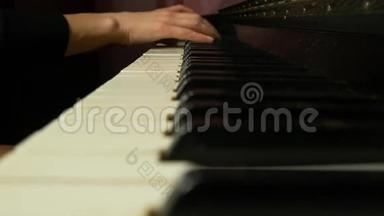 女手在一架漂亮的大钢琴上演奏一首轻柔的古典音乐。 女人弹钢琴，特写..