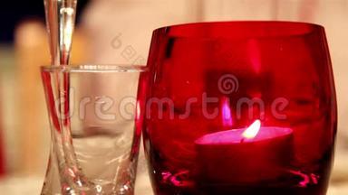 在一个红玻璃杯和一个小玻璃杯里的烛光