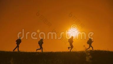 人们徒步旅行的人群幸福地奔跑着，四个人在夕阳的上方遛达着游客阳光下的狗影