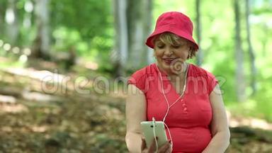 女人坐在森林中一棵倒下的树上，通过智能手机进行交流