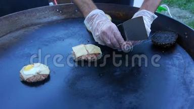 厨师用吹火把把奶酪融化在肉切片上。 厨师用吹火把把奶酪融化在汉堡上。